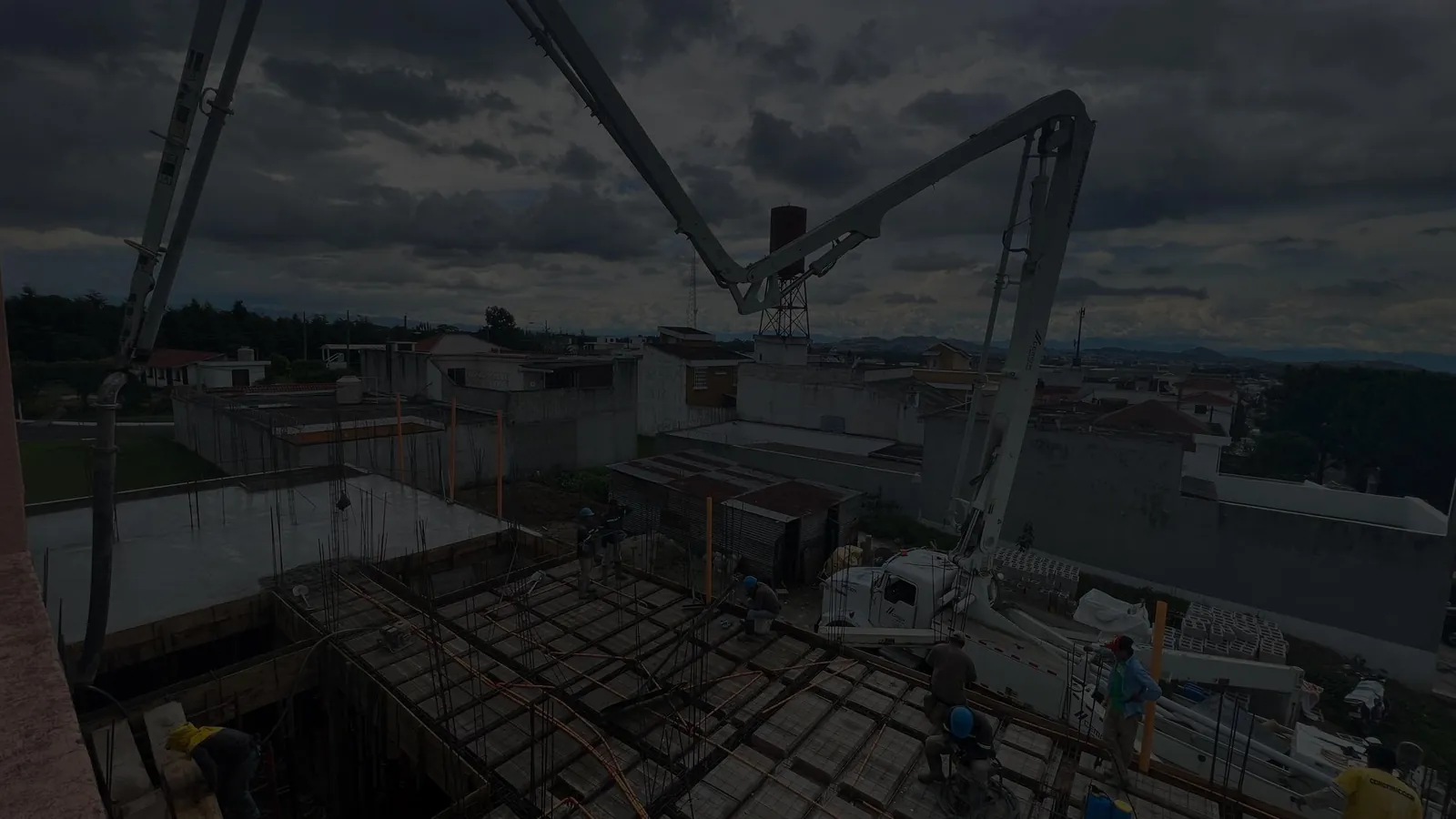 Fundición de concreto con bomba pluma al atardecer